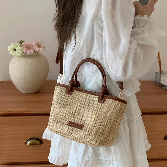 Mała słomiana torebka do ręki z paskiem i ozdobnymi węzłami
